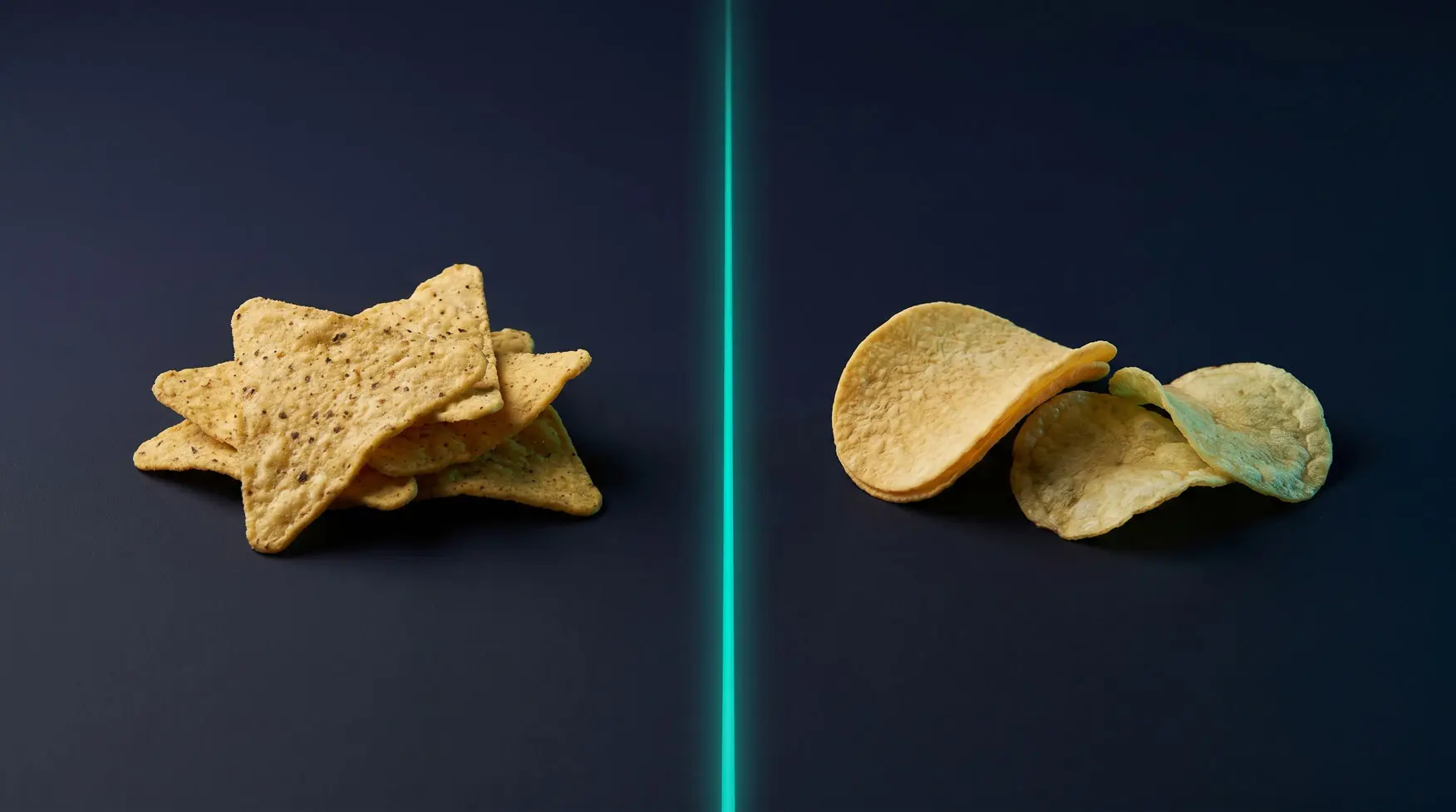 A protein tortilla chip and a regular potato chip side by side on a dark studio surface with a single teal accent rim light.
