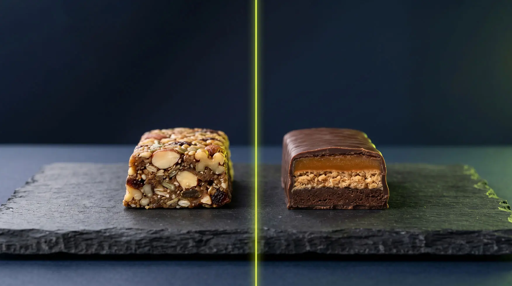 A plant-based protein bar and a whey protein bar side by side on a dark surface